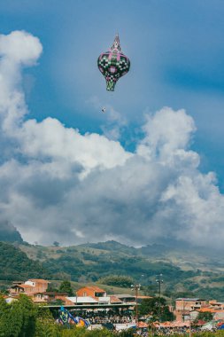 Mavi gökyüzü ile balon festivali ve arkada Tusa tepesi - Venedik, Antioquia, Kolombiya.
