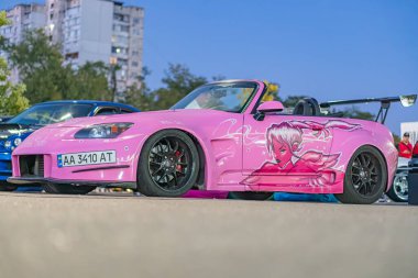 Kentsel gece sokağı Kyiv, Ukrayna 'ya park edilmiş anime grafikli pembe Mazda Miata - 21 Eylül 2025