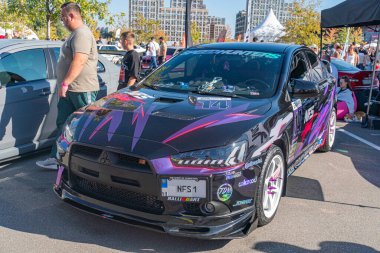 Canlı mor ve siyah, modifiye edilmiş Nissan GT-R spor arabası, performans güncellemeleri, bir araba fuarında ya da benzeri bir etkinlikte sergileniyor. Araç aerodinamik modifikasyona sahip Kyiv, Ukrayna - 21 Eylül 2025