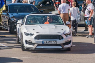 Odak noktası beyaz, turuncu çizgili ve siyah aksanlı modifiye Ford Mustang spor arabası İkincil araba Ac Kyiv, Ukrayna - 21 Eylül 2025