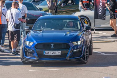 Çarpıcı mavi Ford Shelby GT500 bir galeri zeminine park edilmiş, siyah jantlar ve pencere renkleri, parlak renk, aerodinamik tasarım, parlak ışık, scattere Kyiv, Ukrayna - 21 Eylül 2025