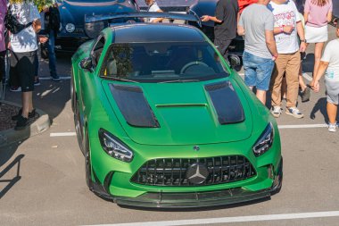 Canlı yeşil bir Mercedes spor arabası, hareketli bir otoparkta duruyor aerodinamik tasarımı ve geniş spoiler yüksek hız kapasitesini vurguluyor Kyiv, Ukrayna - 21 Eylül 2025