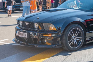 Siyah Ford Mustang arabası halka açık bir etkinlikte, muhtemelen arabalarla ya da sporla ilgili Modifiye edilmiş ya da yarış versiyonu sonraki pazar tekerlekleri ve özel yapım Gündüz Vakti Kyiv, Ukrayna - 21 Eylül 2025