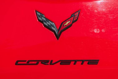 Izgarada ve kaputta belirgin papyon amblemi olan kırmızı bir Chevrolet Corvette 'in yakın çekim görüntüsü. Parlak aerodinamik tasarım ışık yansıtan Kyiv, Ukrayna - 21 Eylül 2025