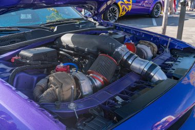 Açık kapüşonlu mavi bir Ford Mustang, kısmen görünür bir yolcu, mor bir korkuluk, ve arka planda gri bir asfalt yol Kyiv, Ukrayna - 21 Eylül 2025