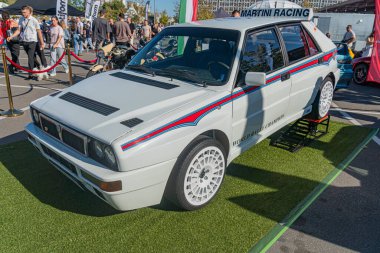 Açık hava araba fuarında klasik çizgili gri Alfa Romeo 'nun arka yüzünde siyah bir spoiler ve arka planda uzak bir araba var. Arka planda Kyiv, Ukrayna - 21 Eylül 2025