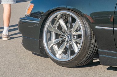 Asfalta parkedilmiş siyah bir BMW 'nin kısa görüntüsü, birden fazla telli gümüş alaşımlı tekerleğe odaklanmış, parlak araba ve karmaşık tekerlek tasarımı Kyiv, Ukrayna - 21 Eylül 2025