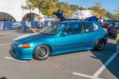 Otoparkta modifiye edilmiş mavi Honda, canlı mavi bir vücut, düşük profil duruşu, arka spoiler, yan etekler, siyah ızgara, çok dilli tekerlekler, beyaz şerit Kyiv, Ukrayna - 21 Eylül 2025