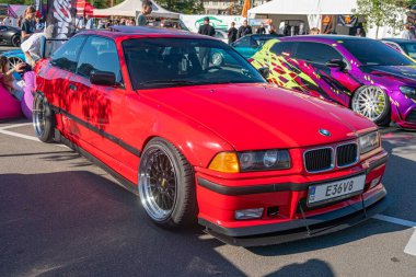 Kırmızı BMW E30, açılı, vücut kiti ve market tekerleriyle, beton plaka üzerine park edilmiş M140 Sahne açık hava etkinliği veya araba hayranları un Kyiv, Ukrayna - 21 Eylül 2025