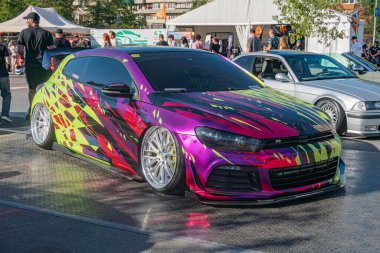 Canlı, mor-sarı araba, çeşitli kalabalık ve araçlarla dolu bir otoparkta göze çarpıyor. Kyiv, Ukrayna - 21 Eylül 2025