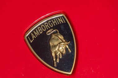 Ferrari anahtarlığının canlı kırmızı arkaplan üzerinde yakın plan, kasıla kasıla yürüyen at amblemi ve FERRARI metni minimalist tarzda, hatta Kyiv, Ukrayna - 21 Eylül 2025