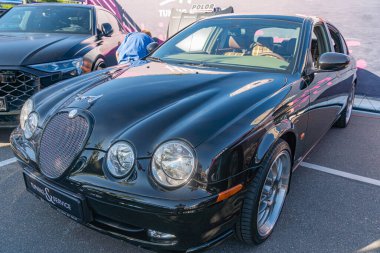 Siyah Bentley ve bir araba fuarında başka bir araba, yansıyan yüzeyler, parlak tasarım, büyük parlak tekerlekler, karşıt beyaz çadır, parlak aydınlatma, katı gölgeler, gerçekçi Kyiv, Ukrayna - 21 Eylül 2025