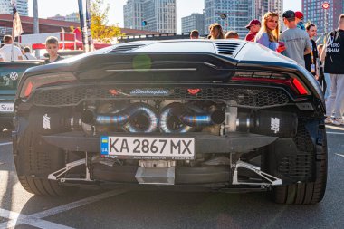 Şehir sokağına park etmiş siyah Lamborghini, gün ışığı altında uzak mesafedeki Pedestrian 'lar. Özel özellikleri Kyiv, Ukrayna - 21 Eylül 2025
