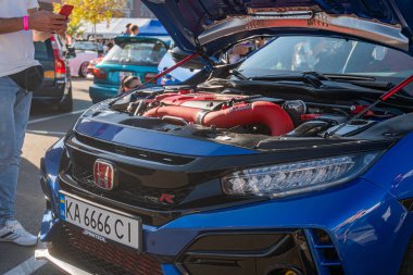 Mavi Honda Civic Type R, açık kaputlu bir caddeye park edilmiş, mekanik parçaları ve modifikasyonları gün ışığına çıkarmış, Avrupa plakası KA 006 C1 A Kyiv, Ukrayna - 21 Eylül 2025