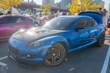 Mavi Mazda spor arabası, pazar sonrası vücut kiti ile, gün ışığında park halinde ya da gösteri alanında, parlak boya, siyah çoklu jantlar, düşük lastik pressu Kyiv, Ukrayna - 21 Eylül 2025