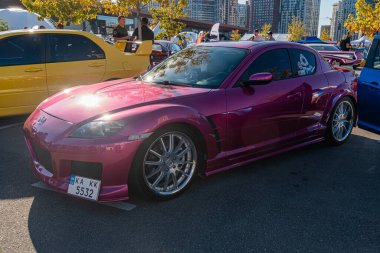 Canlı mor Mazda Miata, park ya da şehir sokağının yakınına park etmiş, zengin doymuş renk, yüksek tavan, pazar sonrası gümüş tekerlekler, doğal ışıklandırma, yumuşak gölgeler, ea Kyiv, Ukrayna - 21 Eylül 2025