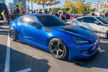 Özel aerodinamik modifikasyonlarla donatılmış mavi Toyota Supra, çok dilli jantlar ve bulanık insan figürleri, Ga Kyiv, Ukrayna - 21 Eylül 2025