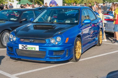 Bir araba fuarında mavi Honda Integra R tipi, beton üzerine park edilmiş şehir ortamında, canlı mavi boya, arka kanat spoiler, altın alaşımlı tekerlekler, siyah kaput deliği, doğal Kyiv, Ukrayna - 21 Eylül 2025