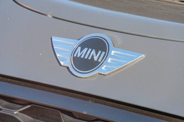 Mini Cooper ön ızgarasının yakın çekimi, marka ikonik gümüş ve mavi dairesel amblemi stilize edilmiş binici ve MINI metni The Grille is a metal mesh Kyiv, Ukrayna - 21 Eylül 2025
