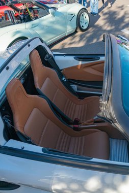 Açık otoparkta üstü açık beyaz spor araba, en üstte, iki koltuk görünür, izleyiciye yönelik diğer arabalar ise arka planda hafif bulanık Kyiv, Ukrayna - 21 Eylül 2025