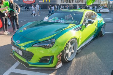 Pist üzerinde özel yapım yeşil bir spor arabanın olduğu canlı bir sahne, biraz merkezden uzak, agresif duruşu ve aerodinamik modifikasyonları olan araba, fac Kyiv, Ukrayna - 21 Eylül 2025