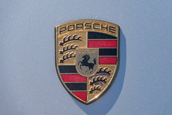 Close-up of a Porsche emblem, circular with central shield bearing a stylized horse and Stuttgart in script Four rings surround the shield two black and two red Kyiv, Ukraine - September 21, 2025