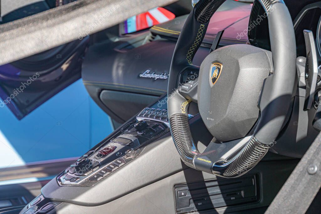 Detailed Lamborghini interior close-up, focusing on steering wheel and dashboard Steering wheel with brand logo, racing harness belt system, sleek contoured dashboa Kyiv, Ukraine - September 21, 2025