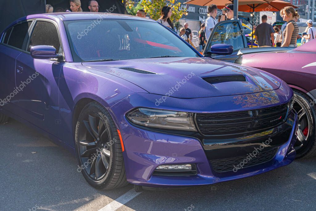 Vibrant purple muscle car in outdoor setting, possibly at a car show Car is frontally positioned with hood open, revealing engine compartment and black grille Head Kyiv, Ukraine - September 21, 2025