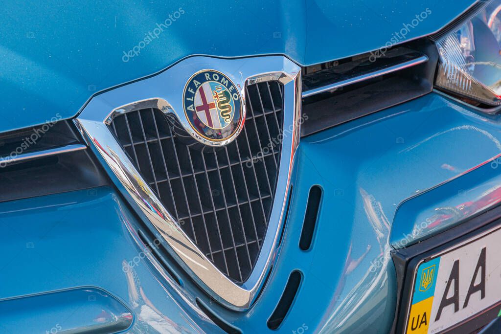 Outdoor daytime scene featuring a blue Alfa Romeo car, partly obstructed by a red and white truck Natural lighting, vibrant blue car contrasting with the red and wh Kyiv, Ukraine - September 21, 2025