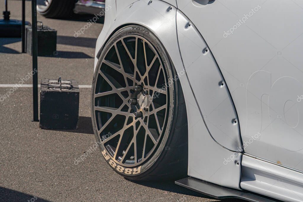 Close-up view of a used, metallic silver sports car with scratched alloy rims, likely performance or aesthetic design Taken from an angled side perspective at a par Kyiv, Ukraine - September 21, 2025