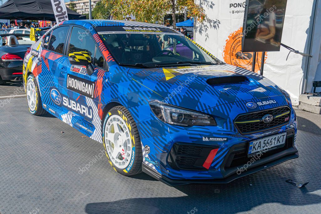 Vibrant blue Subaru racing car parked on a sloped concrete surface, displaying sponsor logos and decals Front grille with headlights, number plate, sporty rims, blu Kyiv, Ukraine - September 21, 2025