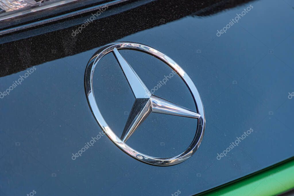 Close-up of a gleaming, metallic Mercedes-Benz emblem on a matte black grill with vertical lines Kyiv, Ukraine - September 21, 2025