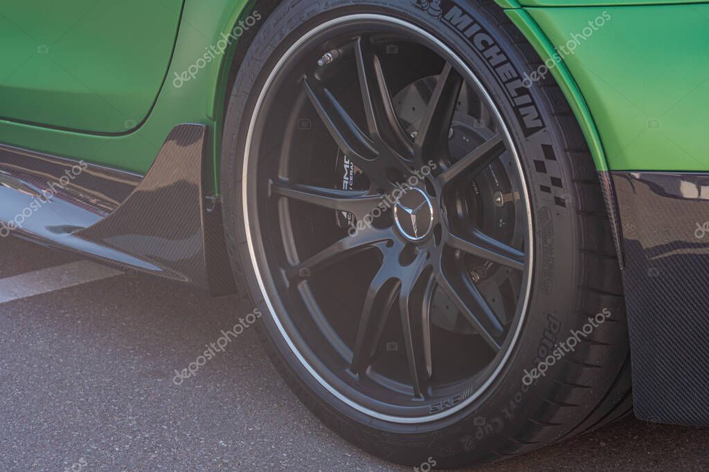 Close-up, car side profile, high-performance alloy wheel with reflective polished edges and logo, well-maintained tire, textured carbon fiber side sill, vibrant car Kyiv, Ukraine - September 21, 2025