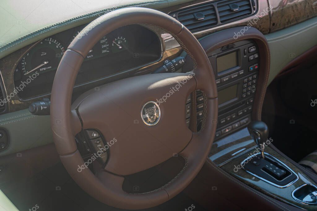 Interior view of a luxury Jaguar car, focusing on the brown steering wheel with brand logo Dashboard controls and instruments present Leather elements in upscale d Kyiv, Ukraine - September 21, 2025