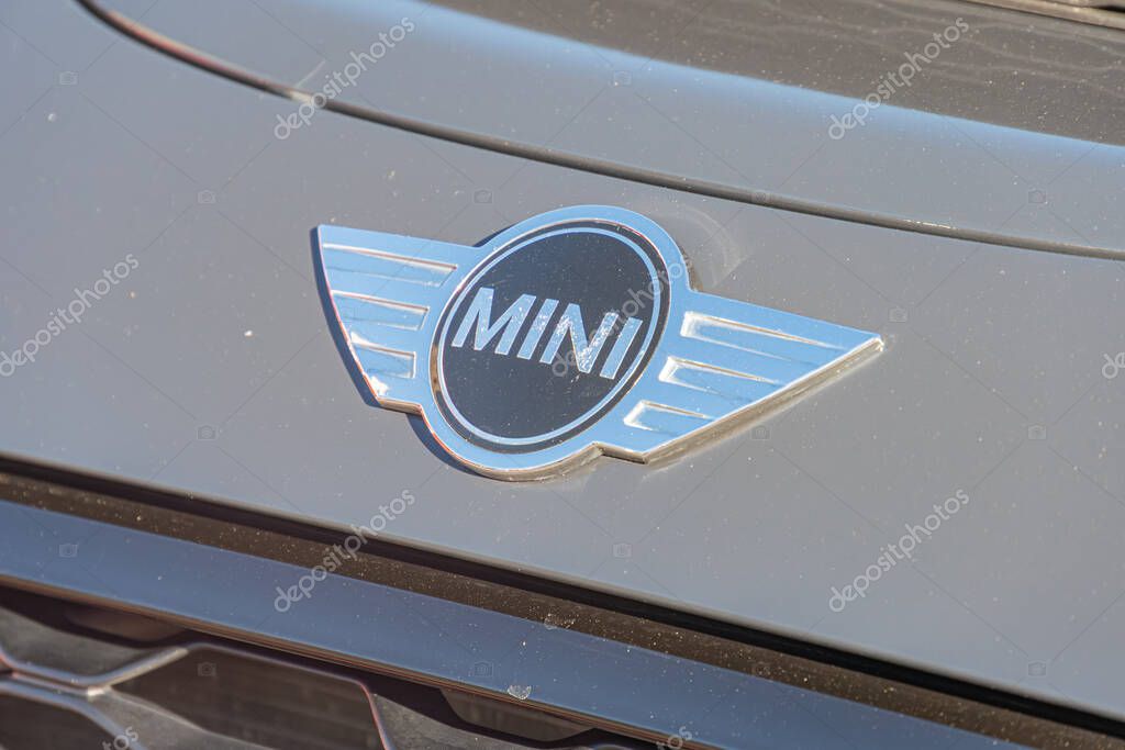 Close-up of Mini Cooper front grille, featuring the brands iconic silver and blue circular emblem with a stylized rider and MINI text The grille is a metal mesh Kyiv, Ukraine - September 21, 2025