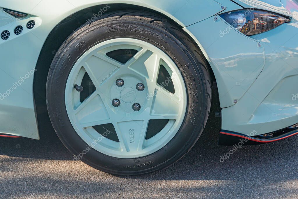 Close-up of blue cars wheel, parked on right side Silver alloy wheel with 5 spokes and center cap featuring car logo Intricate rim design visible, partially obscu Kyiv, Ukraine - September 21, 2025