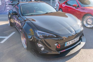 Bir araba fuarında siyah yüksek performanslı Toyota spor arabası, kırmızı fren ayarlı büyük gümüş tekerlekler, belirgin ayrıştırıcı, Kyiv, Ukrayna - 21 Eylül 2025