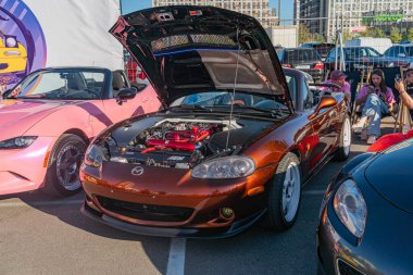 Spor arabaların toplanması, öncelikle açık hava ortamında, merkezinde kahverengi bir Mazda Miata ile motorunu gösteren cilalı dış araçlar ambien Kyiv, Ukrayna - 21 Eylül 2025
