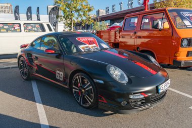Kırmızı aksanlı siyah Porsche spor arabası ve beyaz Porsche metni, bir şehir caddesine park edilmiş dikkat çekici özellikler arasında belirgin farlar, Kyiv, Ukrayna 'nın arka kapısının hava girişleri - 21 Eylül 2025