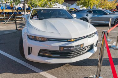 Modern bir beyaz Chevrolet Corvette, muhtemelen bir araba fuarı veya sergisinde sergileniyor. Araç, göze çarpmayan bir sanatçı Kyiv, Ukrayna - 21 Eylül 2025