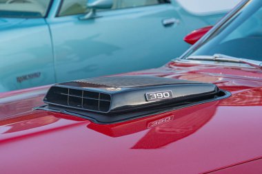 Kaputunda hava kepçesi olan klasik bir kırmızı kaslı araba Ford Mustang, muhtemelen bir otomobil fuarında veya CI Kyiv, Ukrayna - 21 Eylül 2025