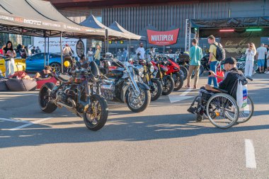 Açık hava motosiklet etkinliği, asfalt yolda çeşitli motosikletler, kalabalığa hayranlık, bireysellik, tekerlekli sandalye kullanıcısı, koltuk değneği kullanıcısı, çeşitlilik, doğal ışıklandırma, sha Kyiv, Ukrayna - 21 Eylül 2025