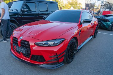 Kırmızı Nissan GT-R arabası, parlak tasarım ve kıvrımlı, gri renkli araç ve yayaların arka planına karşı, Ukrayna 'nın başkenti Kyiv' in önünde 21 Eylül 2025