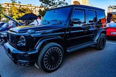 Siyah lüks SUV şehir caddesinde, yumuşak aydınlatma şafak vaktini, görünür diğer araçları, özel gümüş jantları ve ızgaraları, tanımlayıcı bir işaret yok Kyiv, Ukrayna - 21 Eylül 2025