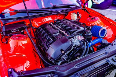 Kırmızı bir otomobil motorunun yakın plan görüntüsü, kapağı kaldırılmış, mekanik parçalar, hortumlar, mavi nesne sol tarafta muhtemelen fanair filtresi, üst Kyiv, Ukrayna 'dan yapay ışıklandırma - 21 Eylül 2025