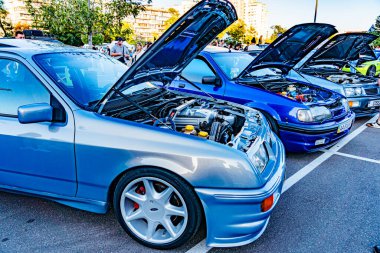 İki modifiye edilmiş performans aracı, gümüş ve mavi, kaputları açık park edilmiş, iyi bakımlı motorlar, Kyiv, Ukrayna - 21 Eylül 2025