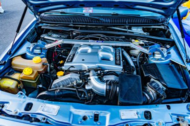 Yakın plan, iyi bakımlı bir araba motoru kompartımanının ön yüzü, cilalanmış metal parçaları, organize hortumlar ve dış kablolar, doğal ışıklandırma Kyiv, Ukrayna - 21 Eylül 2025