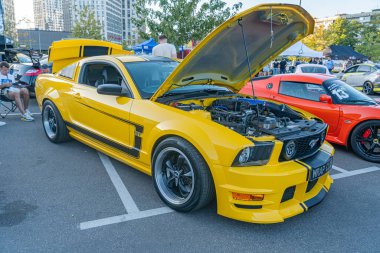 Sarı Ford Mustang, açık kaput, yarış modifikasyonları, sokak dekorasyonu, otomobil fuarı veya toplama, canlı doğal ışıklandırma, gündüz vakti, şık tasarım Kyiv, Ukrayna - 21 Eylül 2025