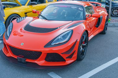 Canlı turuncu McLaren spor arabası, şehir caddesinde köşegen olarak park edilmiş, öncelikle soldan sağa aerodinamik dizayn edilmiş, yan girişleri ve geniş ön havası olan Kyiv, Ukrayna - 21 Eylül 2025