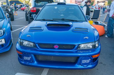 Mavi Subaru açık hava otomobil etkinliğinde sergileniyor. Geniş gövdeli, canlı mavi renkli Mitsubishi Lancer Evolution IX modifiye edildi. Piyasa tamponları, yan etekler, büyük Kyiv, Ukrayna - 21 Eylül 2025